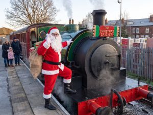 Santa climbs aboard the steam engine with his sack of presents as families wait on the platform in Leeds