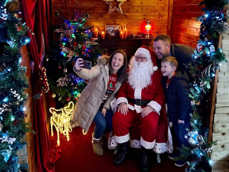 Family taking a selfie with Santa in his grotto at Middleton Railway's Santa Specials in Leeds